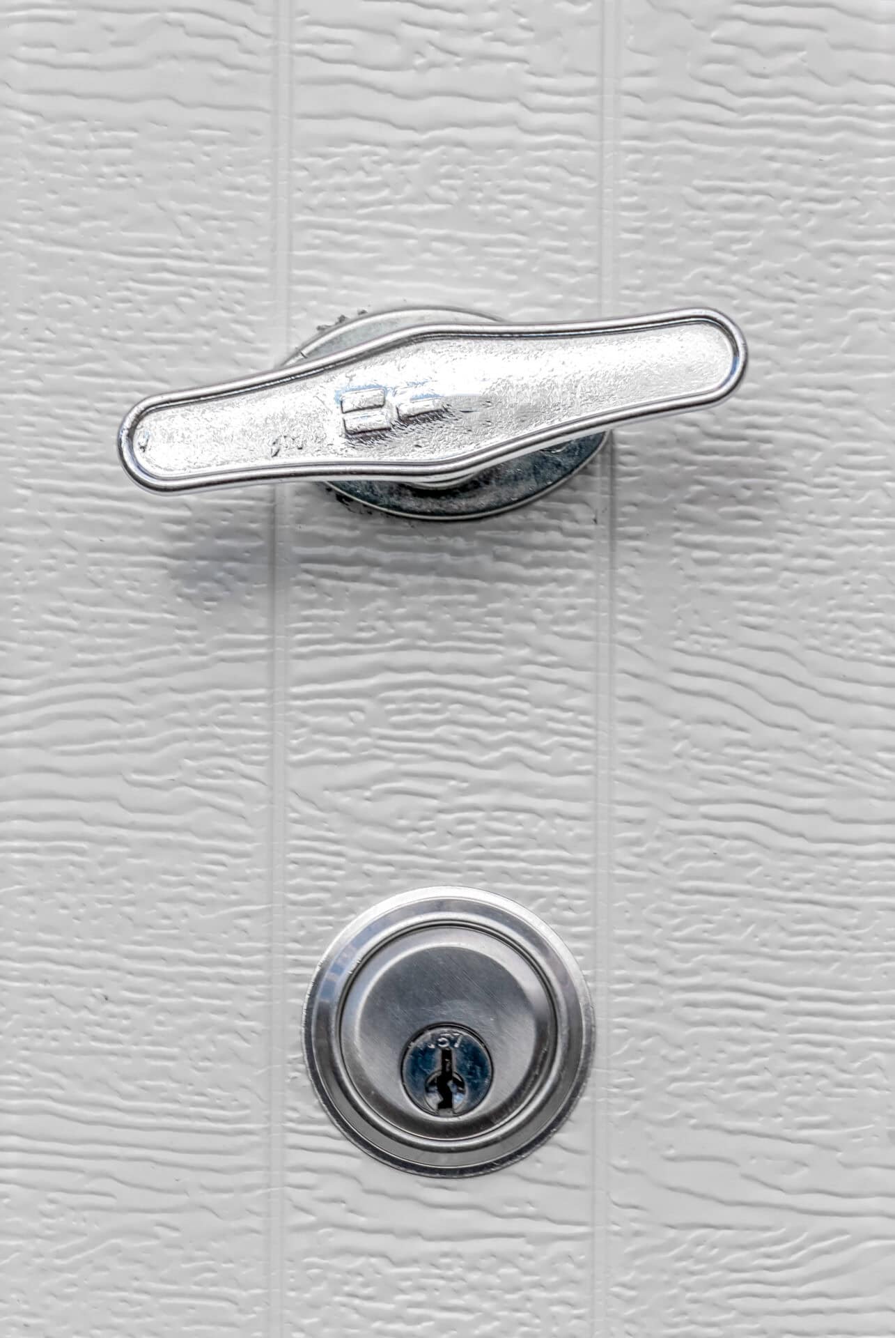 Close-up of a garage door handle and key-operated lock