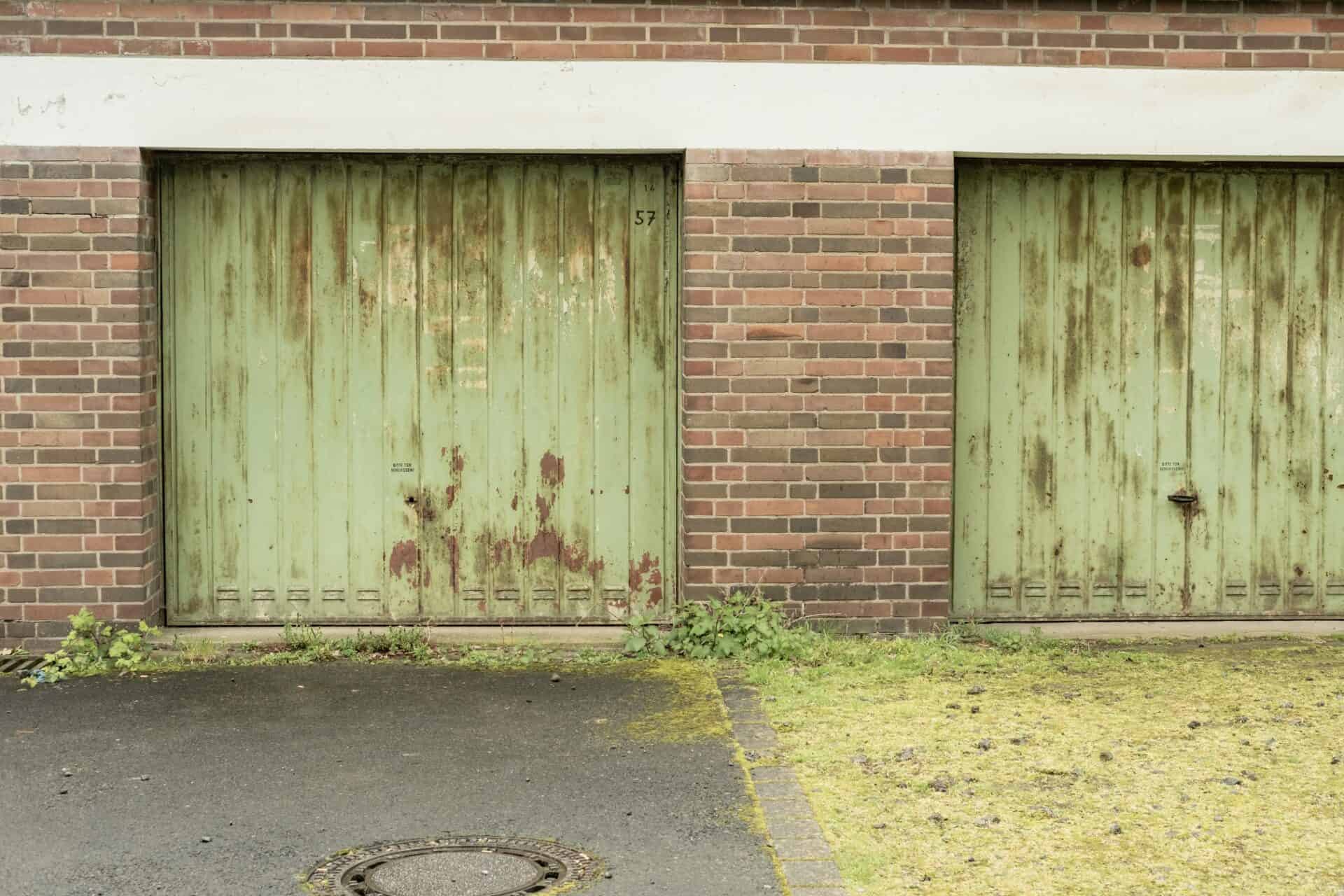Two ageing metal garage doors showing signs of rust and wear